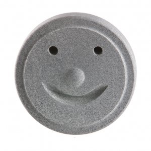 Fun sauna stone with smiling face for relaxation and warmth.