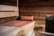 Brown Rento Pino sauna cushion on a wooden bench in a sauna.