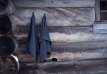 Grey Rento sauna towel of 50x70 cm, hanging on a wooden wall.