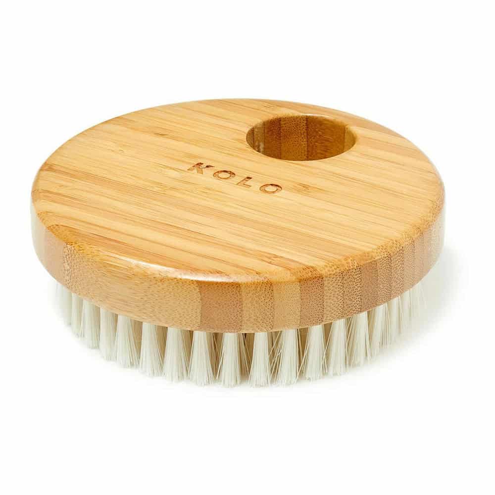 Bamboo body brush, round, with soft white bristles for skin care.