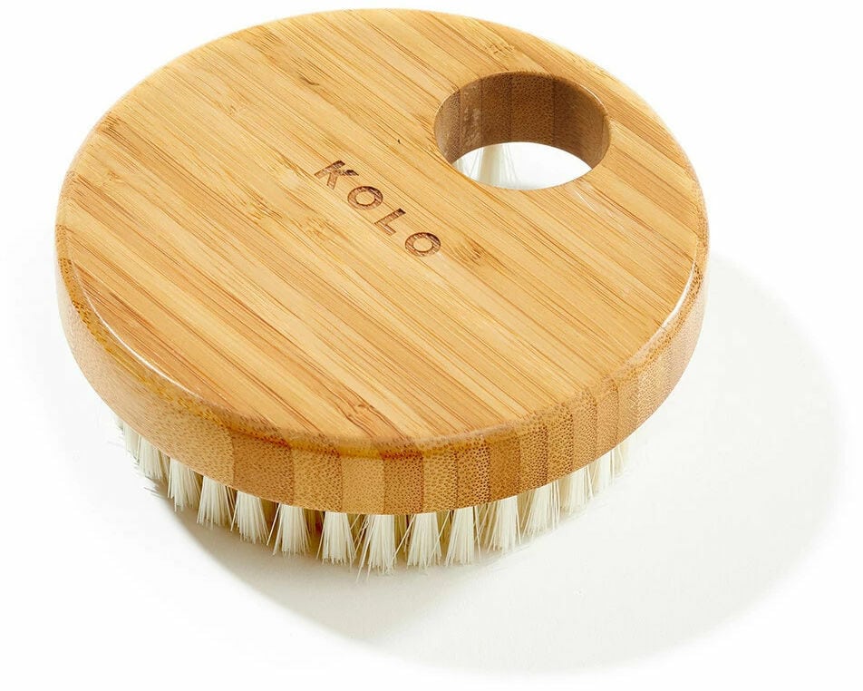 Round bamboo body brush with natural bristles for skin care.