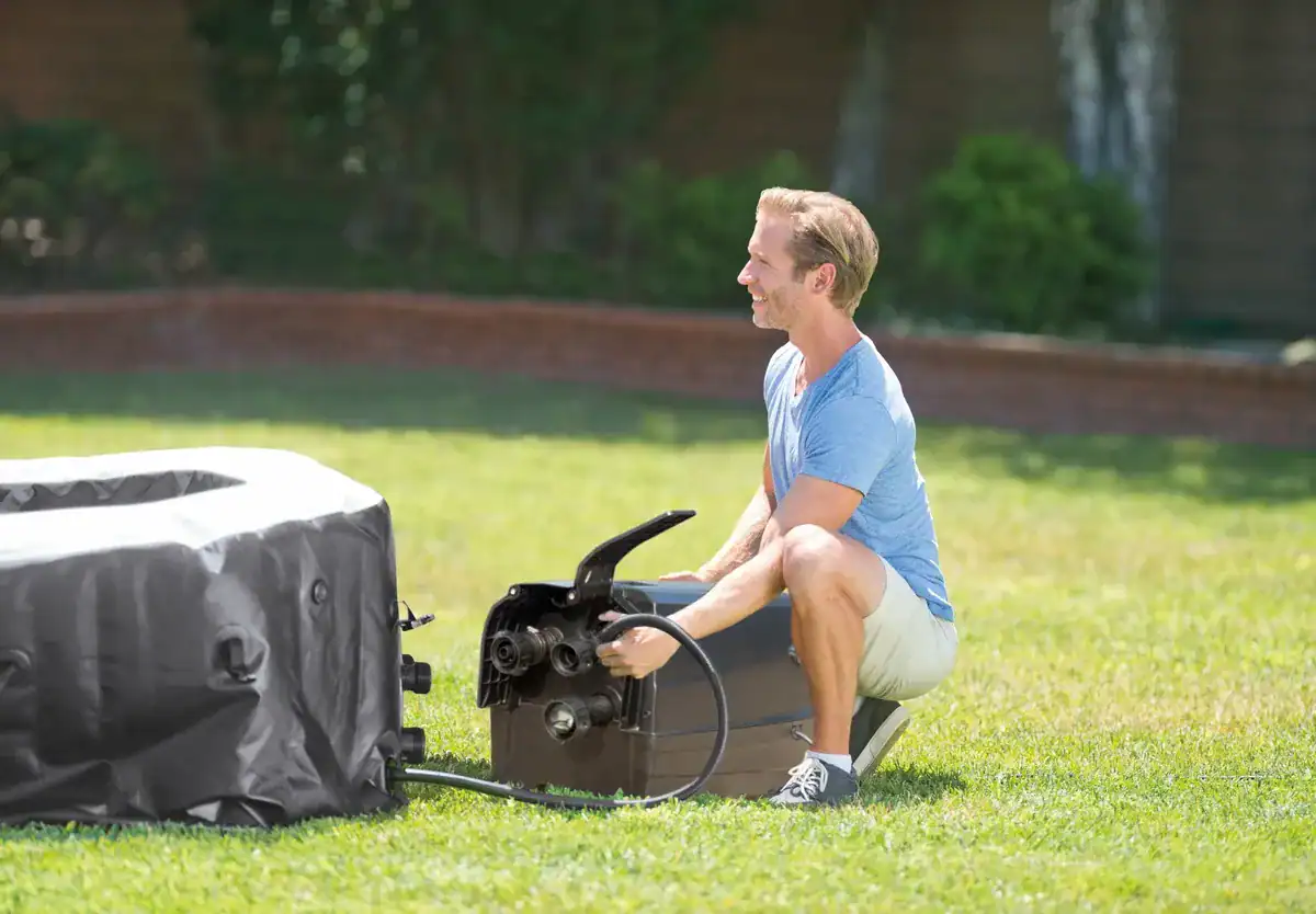 Man installing Intex Pure Spa Jet & Bubble Deluxe in the garden.