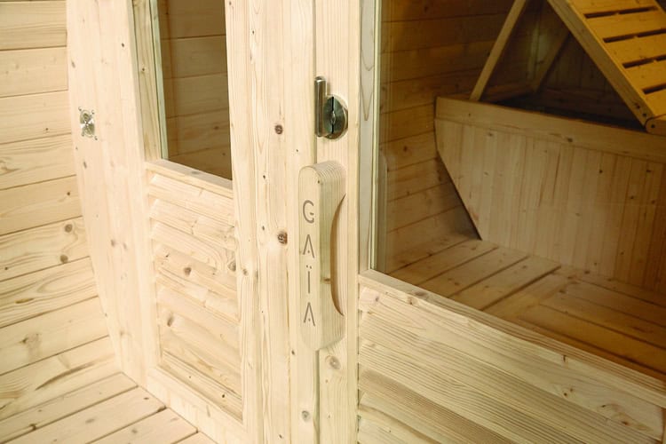 Gaia Luna outdoor sauna with wooden door and accessories.