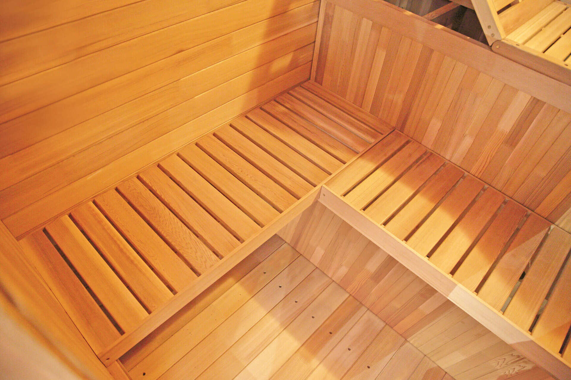 Outdoor sauna made of spruce wood with benches and accessories.
