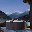 Luxury 6-person inflatable spa with wooden surround and mountain view.